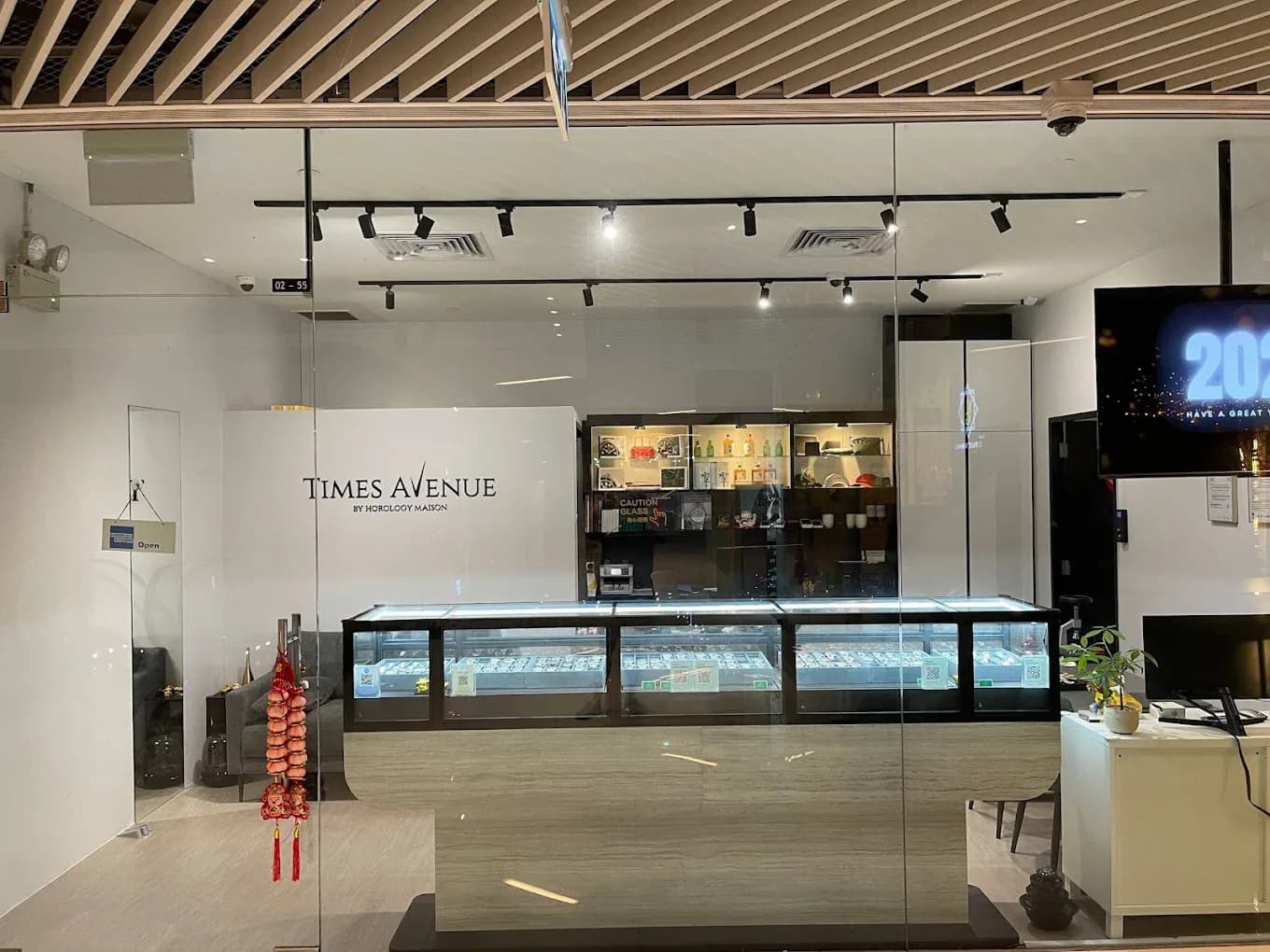 The watch showroom at Times Avenue, display cases under a lit Times Avenue sign