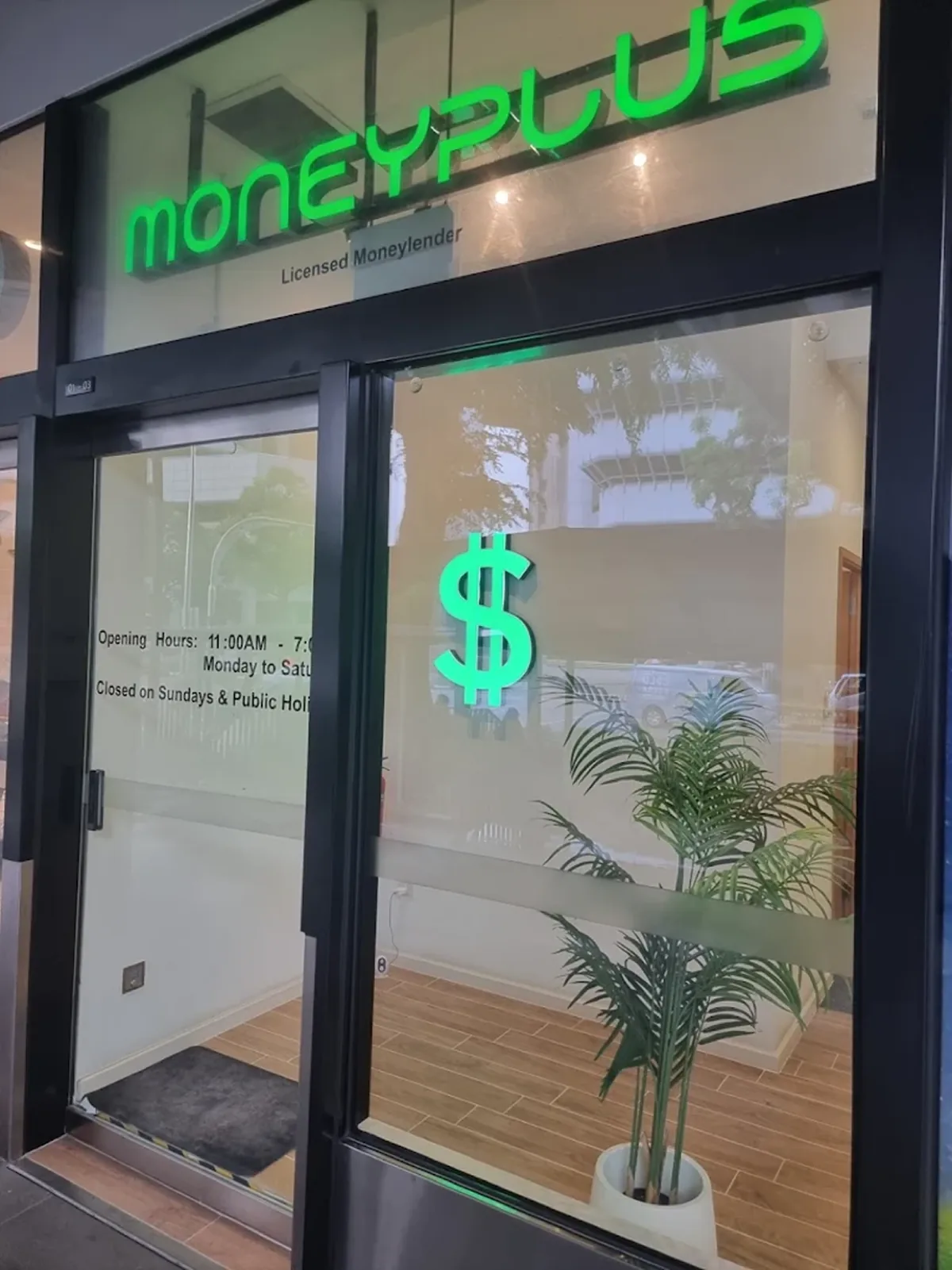The MoneyPlus licensed moneylender storefront at City Gate, green signage above the glass entrance