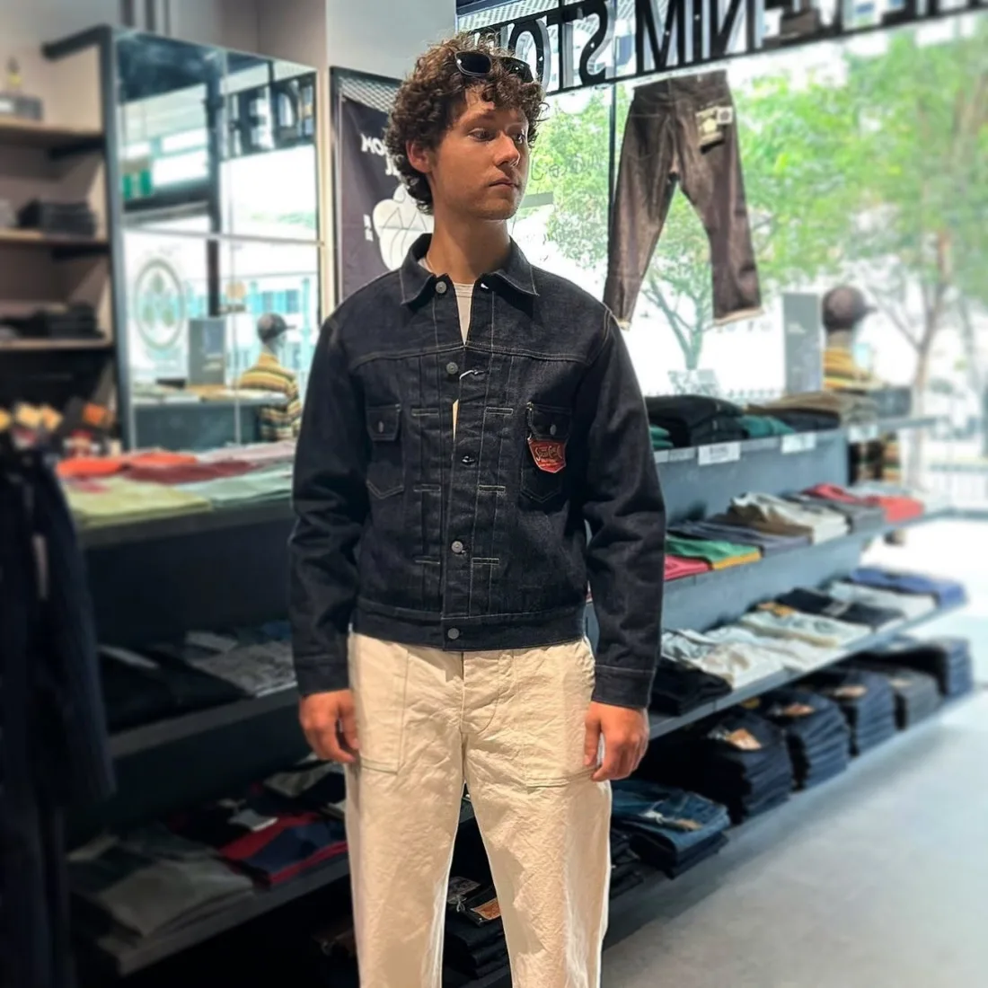 A customer in a raw denim jacket and natural trousers inside The Denim Store at City Gate