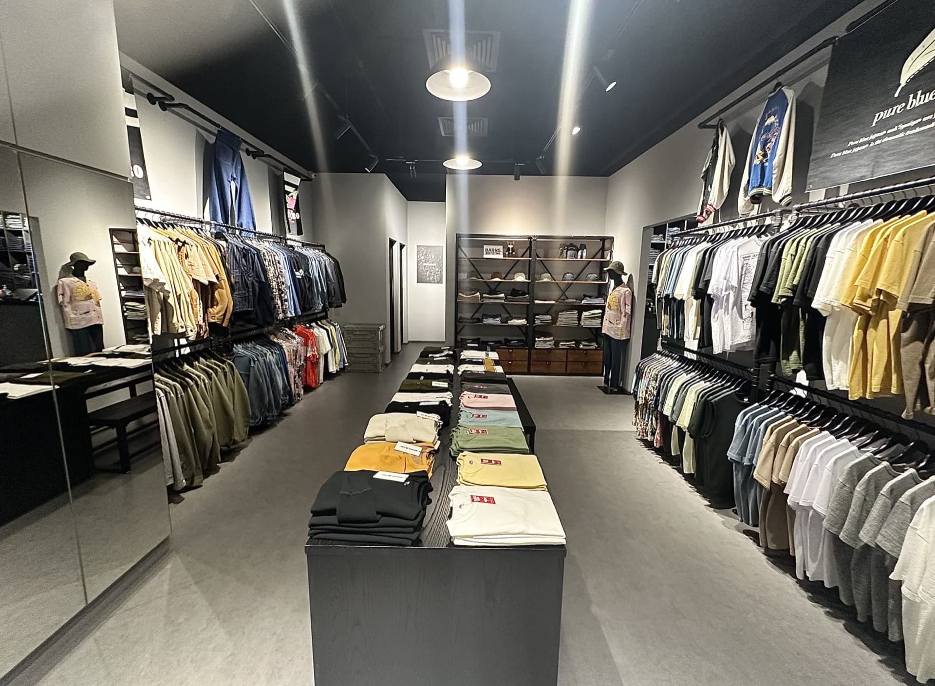 Inside The Denim Store at City Gate — racks of selvedge jeans and shirts around a central folded display