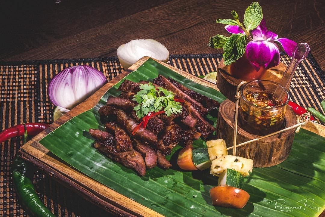 Grilled Thai beef on a banana leaf with jaew dipping sauce and orchid at Beerthai House, City Gate