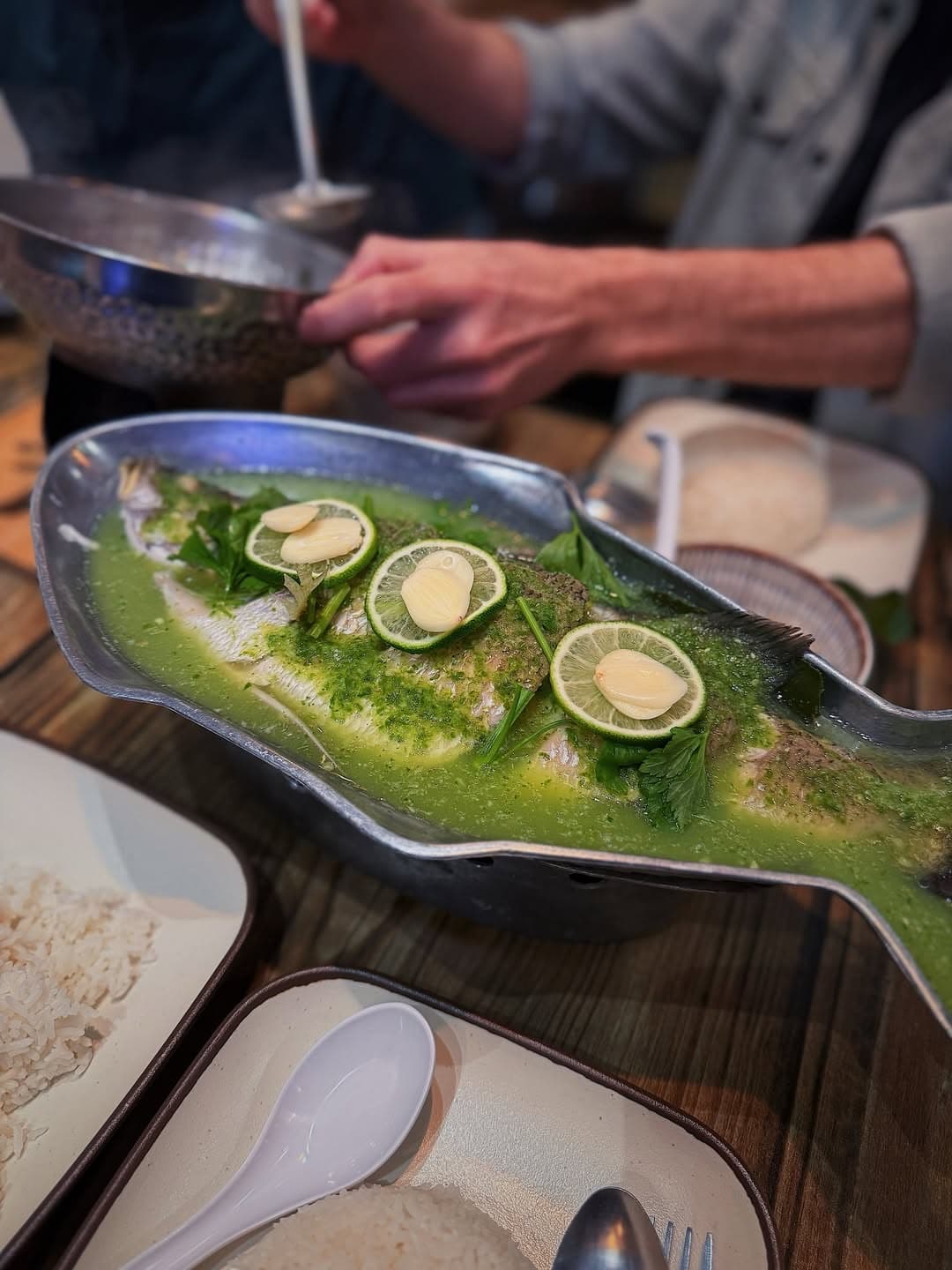 Thai steamed lime fish in a fish-shaped dish, served with rice at Ma Der Kin Khao, City Gate