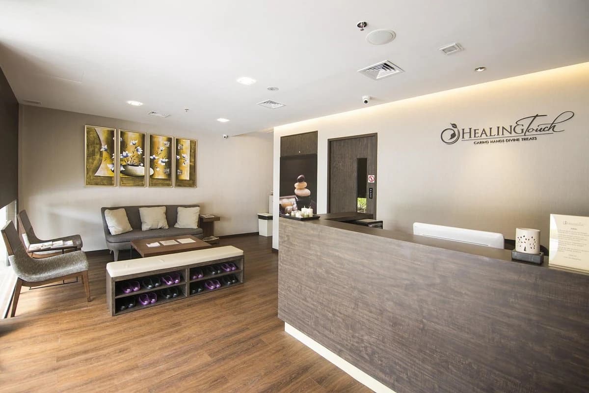 The Healing Touch spa reception at City Gate, its branded logo wall above a warm waiting area