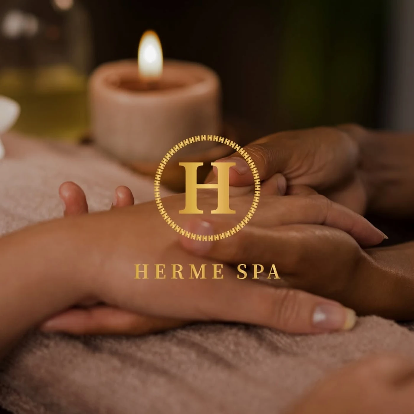A candlelit hand massage at Herme Spa, City Gate, beneath the gold Herme Spa logo