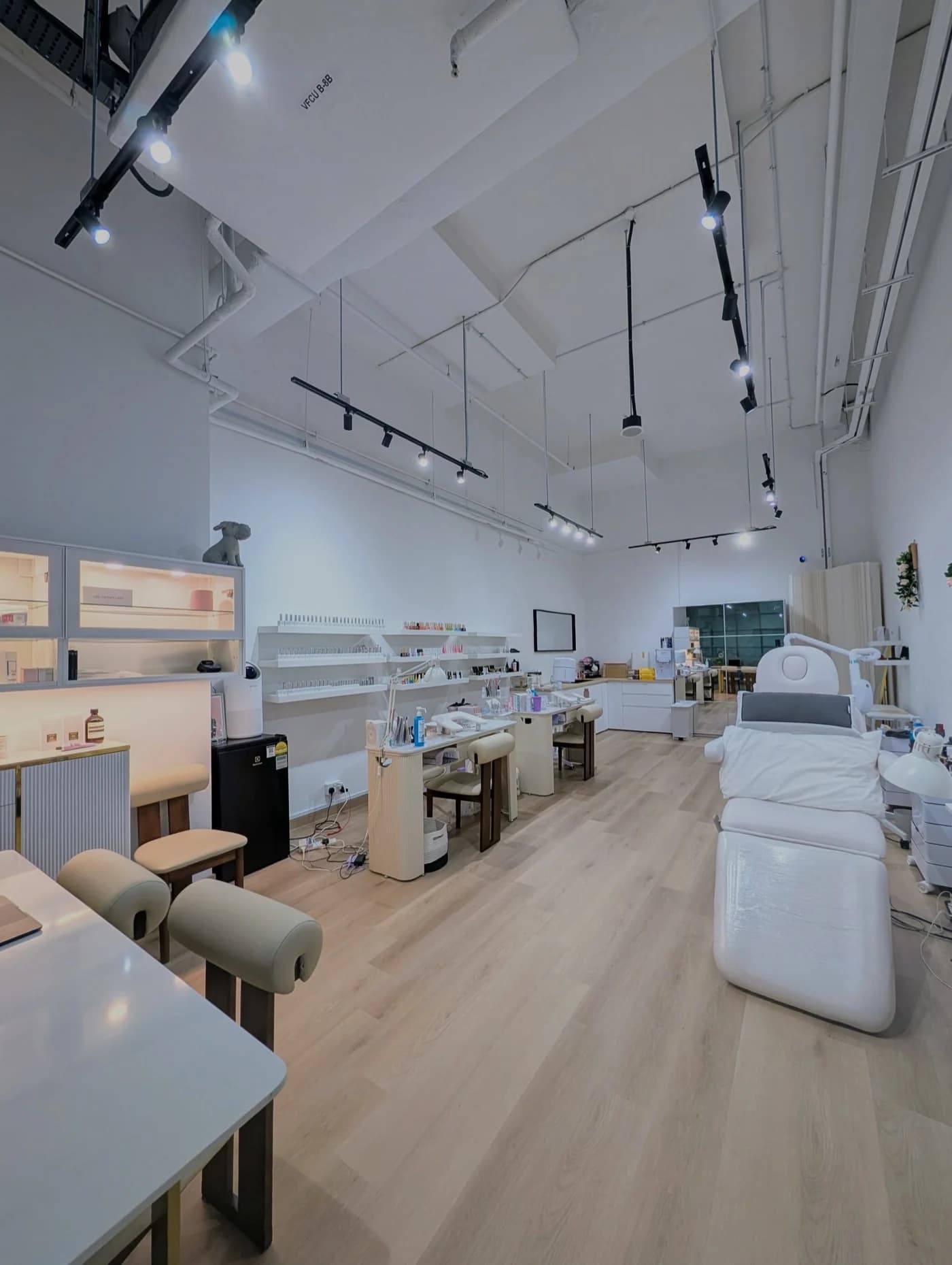 The bright interior of Lume Beauty Bar at City Gate, with manicure stations, a nail-polish wall and a treatment bed