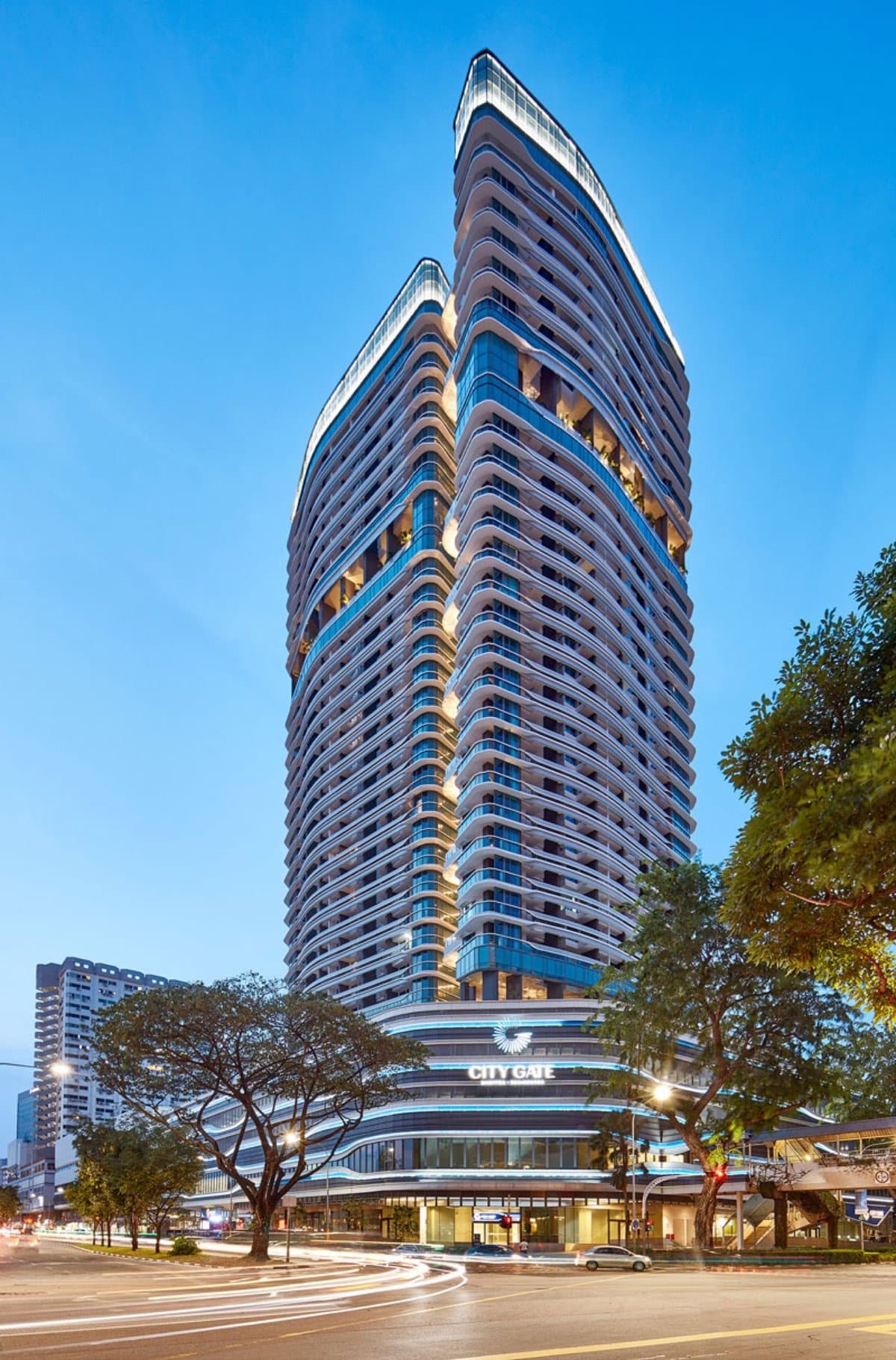 City Gate at dusk, the lit tower above the mall at 371 Beach Road, seen from the junction
